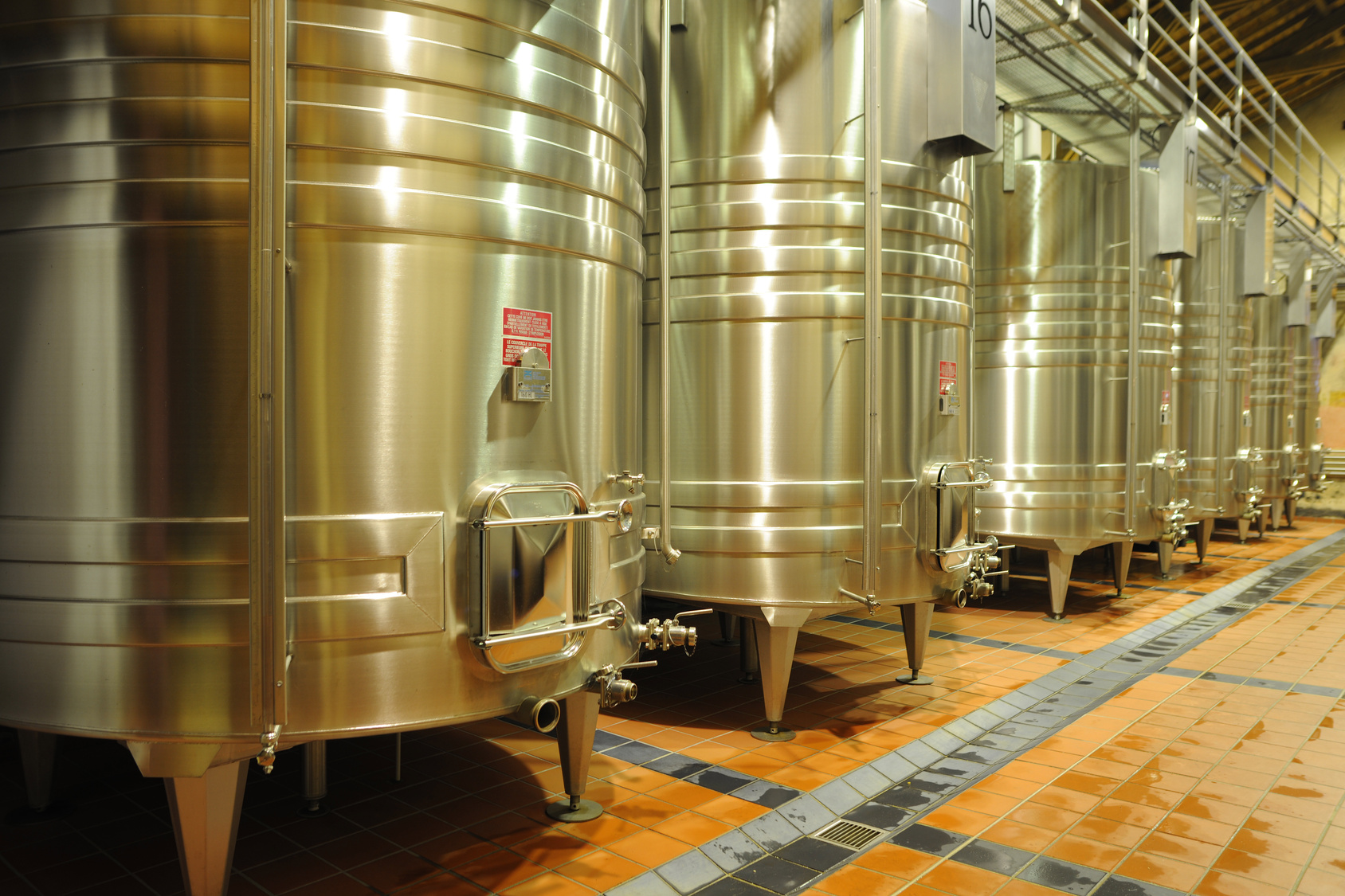 winemakers in cellar using electronic tablet